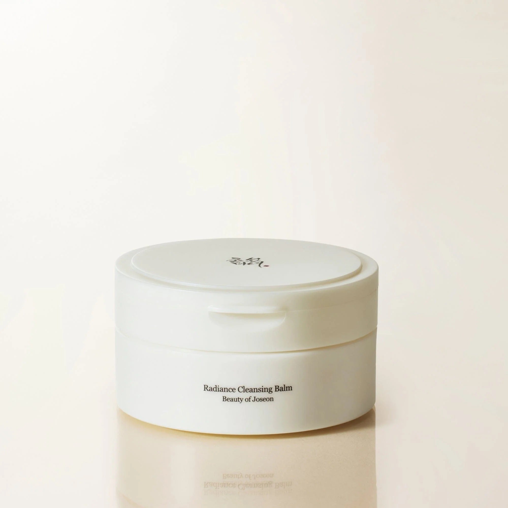 White jar of Radiance Cleansing Balm by Beauty of Joseon on a beige background